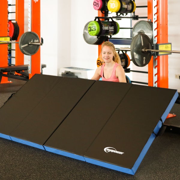 Eine faltbare, schwarze Trainingsmatte in einem Fitnessstudio