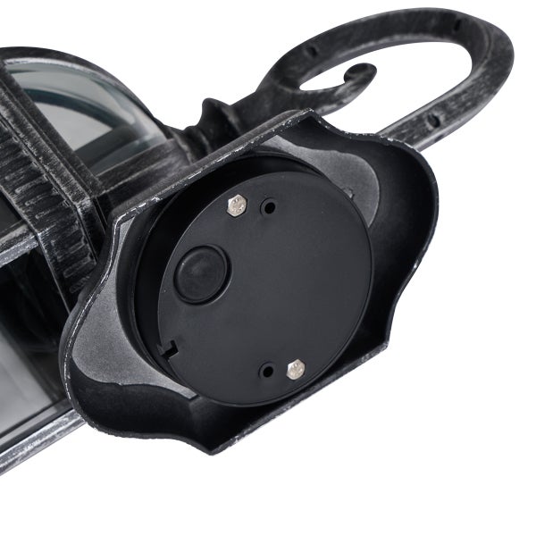 Nahaufnahme der Wandhalterung und des verzierten Arms einer Außenleuchte aus Metall.