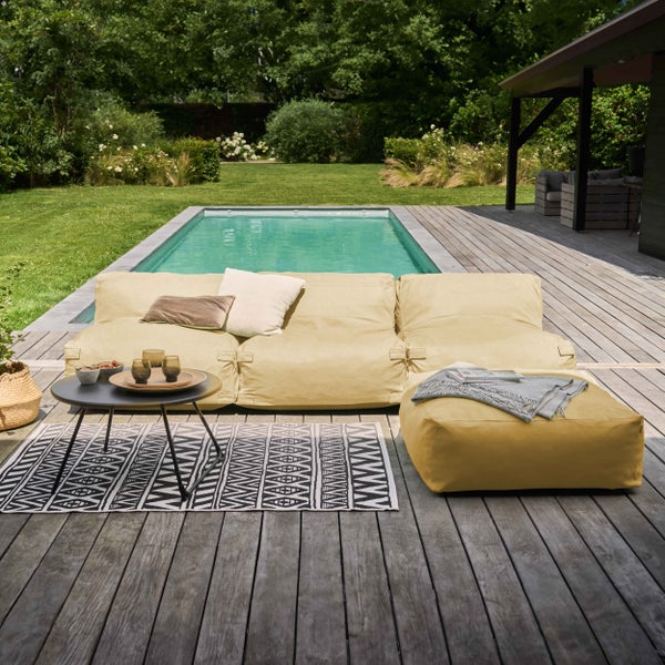 Modernes Outdoor-Lounge-Set mit modularem Sitzsack-Sofa und Hocker auf einer Holzterrasse am Pool im Garten.
