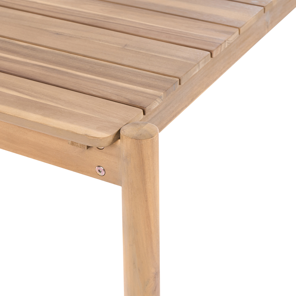 Nahaufnahme einer Ecke eines Garten-Holztischs mit Lattenoberfläche und einem runden Tischbein.