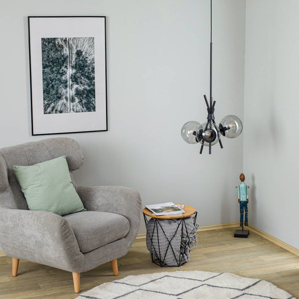 Wohnzimmer mit Sessel, Beistelltisch, Pendelleuchte und Dekoration