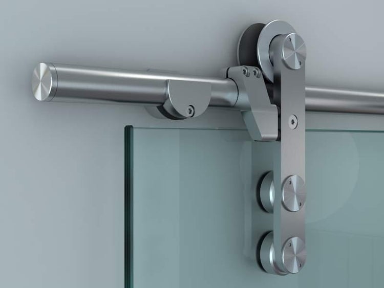 Runde Griffmuschel aus Metall an einer Glasschiebetür in einem Wohnzimmer.