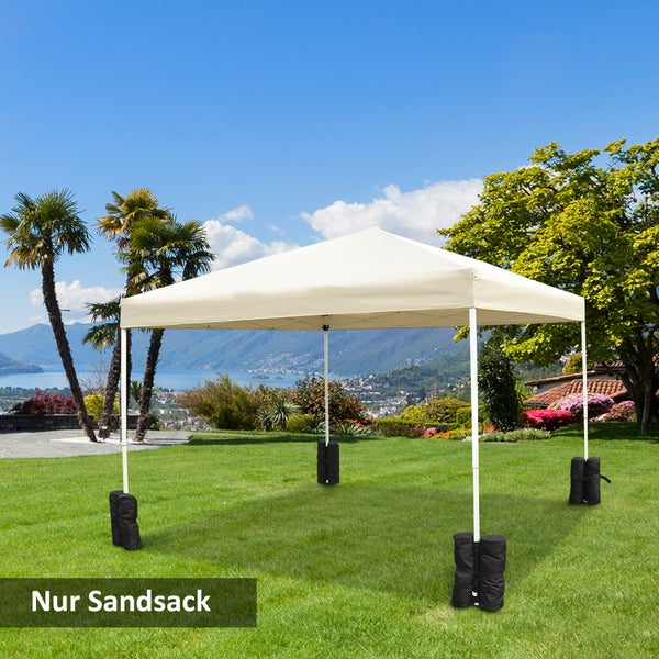 Schwarze Sandsäcke zur Stabilisierung der Standbeine eines Gartenpavillons auf einer Rasenfläche mit Gebirgslandschaft im Hintergrund.