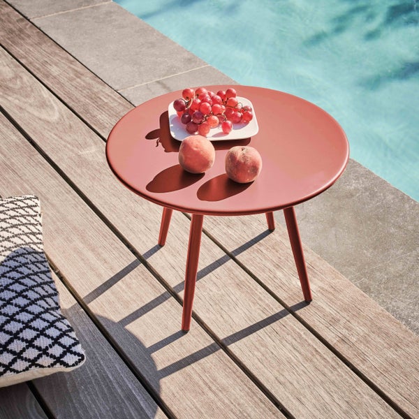 Runder Beistelltisch aus Metall auf einer Holzterrasse am Pool mit Weintrauben und Pfirsichen.