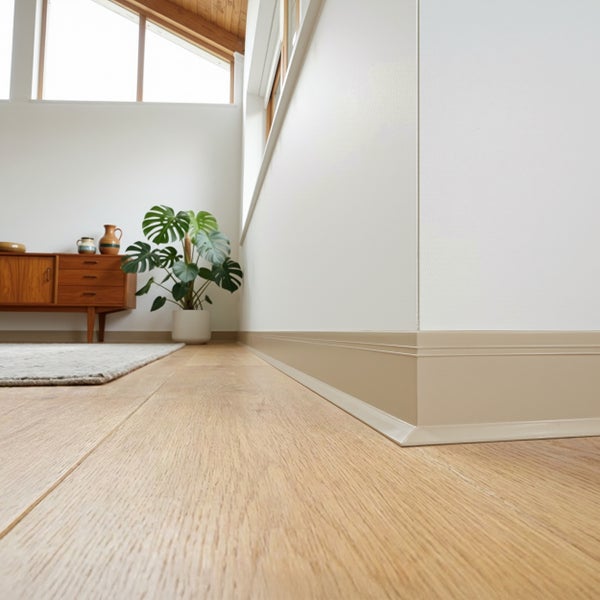 Moderne Sockelleiste an einer Wand in einem hellen Wohnzimmer mit Holzboden und Mid-Century Kommode.