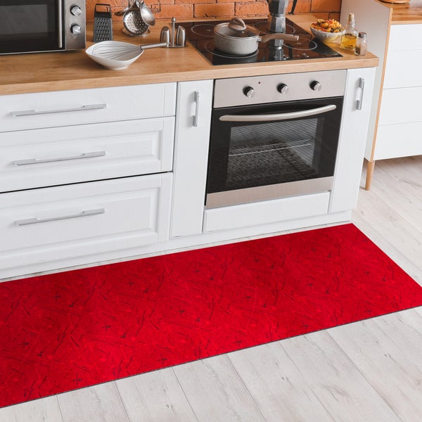 Rote Küchenmatte vor weißen Küchenschränken und Geräten