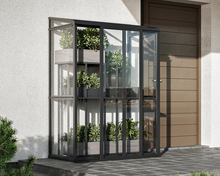 Helles, organisiertes Anlehngewächshaus aus Glas und Metall mit Pflanzen auf mehreren Ebenen an einer Wand neben einer Tür.