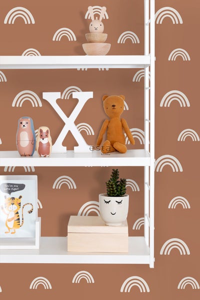 Regal mit Dekorationsgegenständen und Kinderspielzeug vor einer Wand mit Regenbogenmuster.