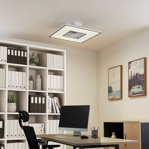 Quadratische LED-Deckenleuchte mit integriertem Ventilator in einem modernen, hellen Arbeitszimmer mit Schreibtisch und weißem Regal.