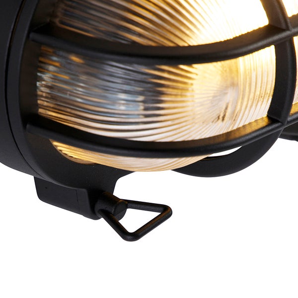 Detailansicht einer beleuchteten schwarzen Außenleuchte mit Schutzgitter und gerippter Abdeckung.