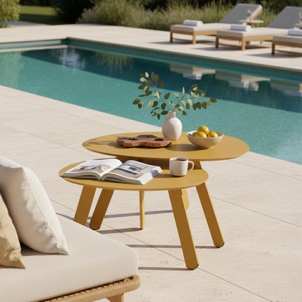 Zweiteiliges Beistelltisch-Set in Senfgelb auf einer sonnigen Terrasse am Pool mit moderner Lounge-Atmosphäre.