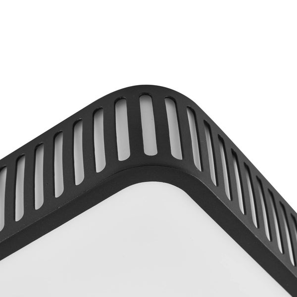 Detailaufnahme einer modernen Lampe mit schwarzem Metallrahmen, vertikalen Schlitzen und weißem Diffusor.