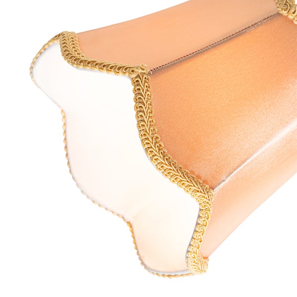 Nahaufnahme eines Lampenschirms aus Stoff mit geschwungenem Rand und verzierter Borte.