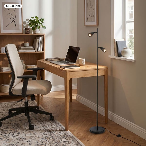Moderne schwarze Stehleuchte mit zwei verstellbaren Strahlern in einem hellen, organisierten Home Office mit Holzschreibtisch und Bürostuhl.