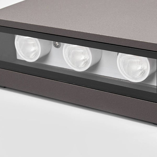 Nahaufnahme einer rechteckigen Außenwandleuchte mit drei LED-Lichtquellen in einem anthrazitfarbenen Gehäuse.