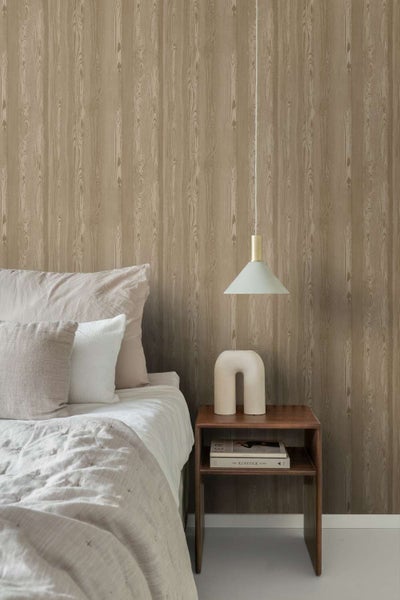 Schlafzimmer mit Vliestapete in Holzoptik mit vertikaler Maserung, kombiniert mit einem Nachttisch aus Holz und einer Pendelleuchte.