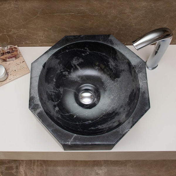 Oktogonales Aufsatzwaschbecken aus dunklem Naturstein mit verchromter Armatur in der Draufsicht.