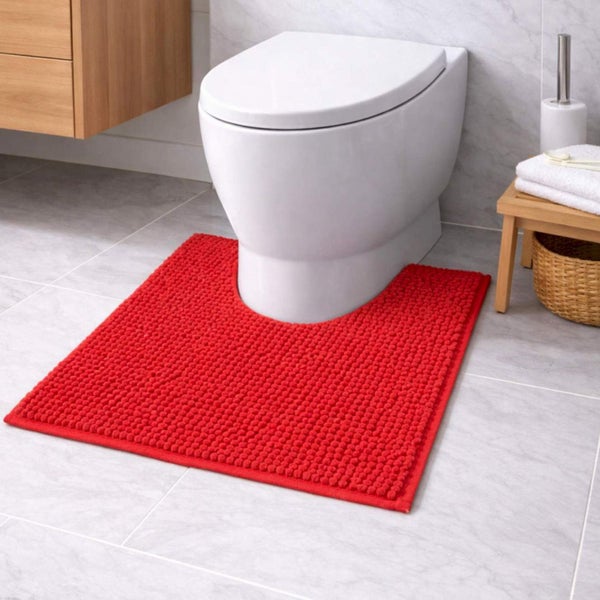 Roter WC-Vorleger mit Ausschnitt und Noppenstruktur vor einer weißen Toilette in einem hellen Badezimmer.