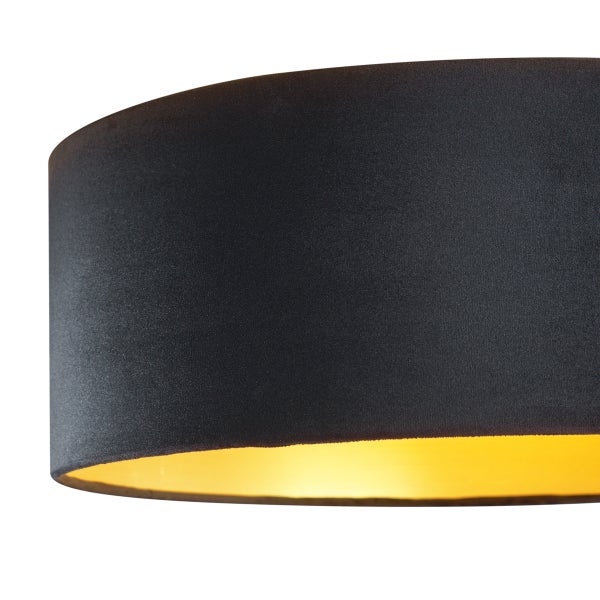 Zylindrischer Lampenschirm aus dunklem Stoff mit goldfarbener Innenseite.