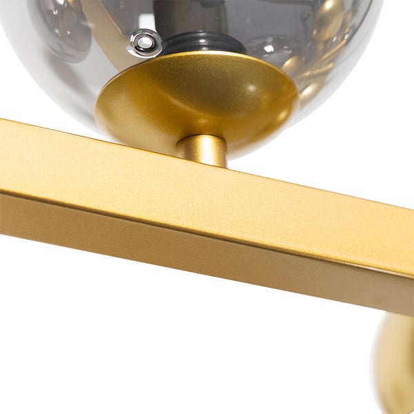 Detailaufnahme einer goldenen Deckenleuchte mit Glaslampenschirmen.