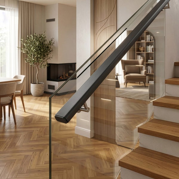 Treppe mit Glasgeländer und dunklem Handlauf in einem modernen Wohnzimmer mit Parkettboden, Kamin und Olivenbaum.