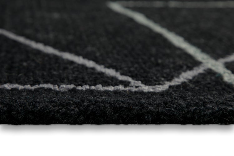 Nahaufnahme eines Teppichs mit geometrischem Muster und weicher Textur.
