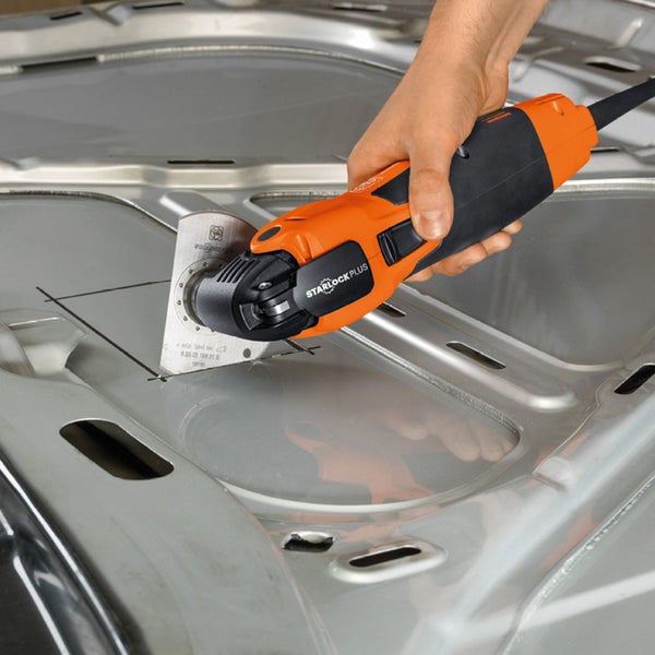 Eine Hand hält ein oszillierendes Elektrowerkzeug beim Schneiden von Metall.