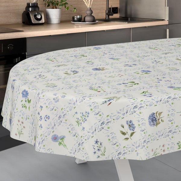 Ovale Tischdecke mit floralem Muster in Blau und Grün in einer hellen, organisierten Küche mit Arbeitsplatte aus Holz.