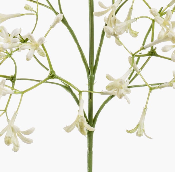 Künstlicher Zweig mit vielen kleinen weißen Blüten an einem grünen Stiel.