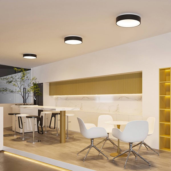 Drei runde, schwarze LED-Deckenleuchten in einem modernen Flur, dargestellt in warmweißem und neutralweißem Licht.