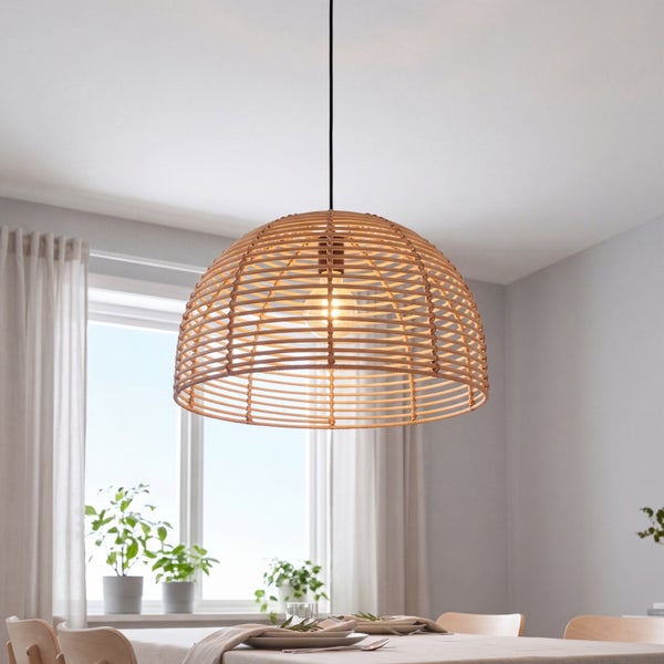 Moderne Hängeleuchte aus Rattan in Kuppelform über einem gedeckten Esstisch in einem hellen, wohnlich eingerichteten Esszimmer.