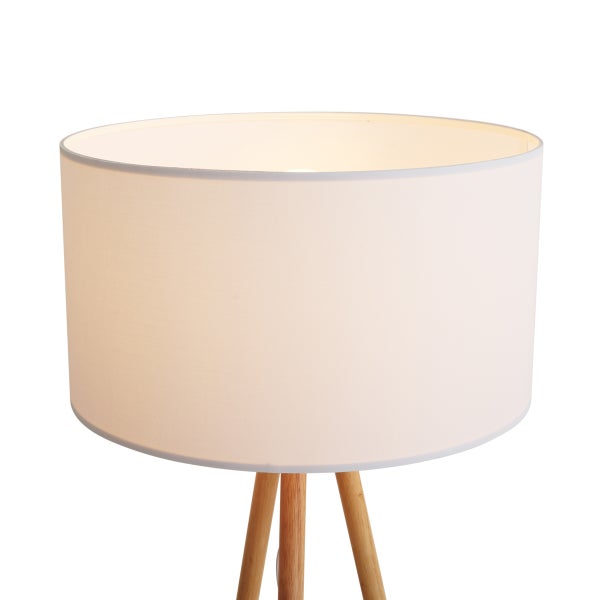 Lampe mit weißem Textilschirm und hölzernem Dreibein-Gestell.