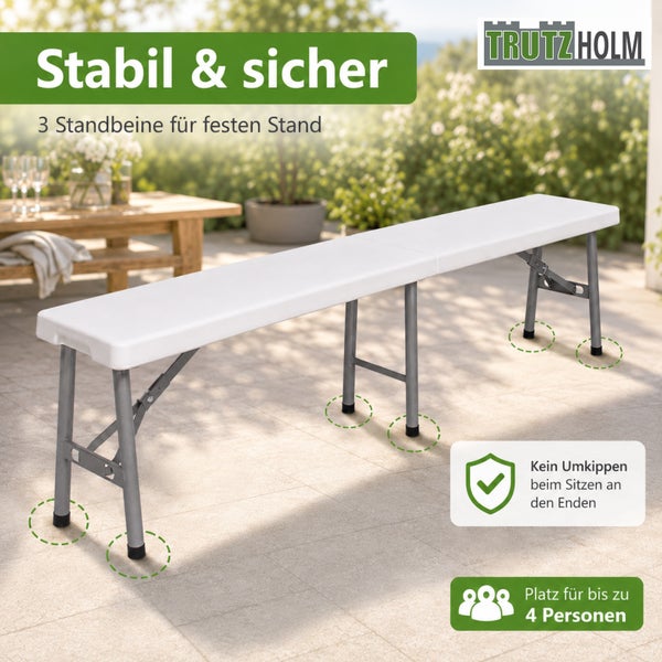 Weiße Klappbank von TrutzHolm mit drei Standbeinen für stabilen Halt und Platz für bis zu vier Personen auf einer Terrasse.