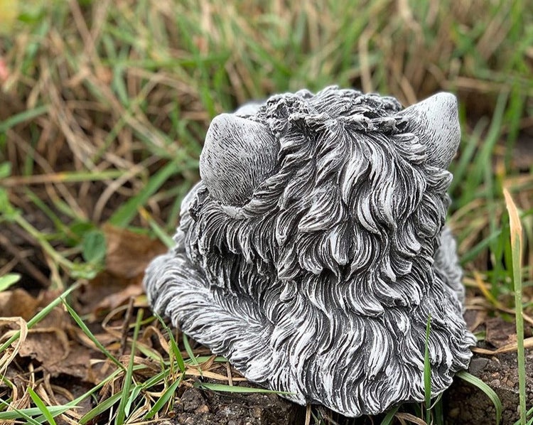 Gartenfigur Katze aus Steinguss von hinten im Gras, mit detailreich strukturiertem Fell.