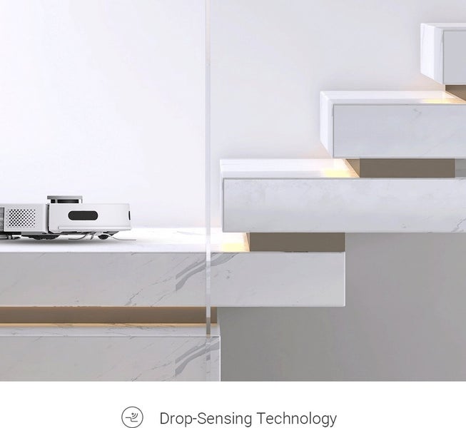 Saugroboter mit Treppenerkennung an der Kante einer Treppe in Marmoroptik.