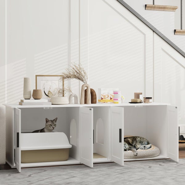 Weißer Katzenschrank in einem hellen Raum, mit integrierter Katzentoilette, einem Durchgang und einem Katzenbett. Oben mit Vasen dekoriert.