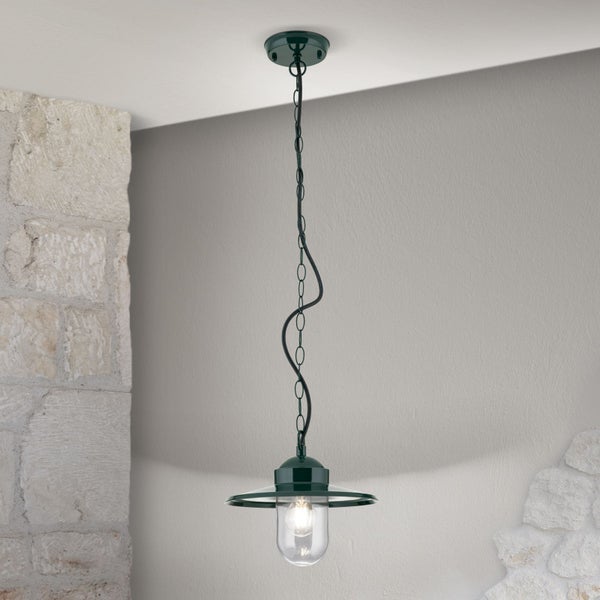 Dunkelgrüne Pendelleuchte aus Metall mit Kette und Glasschirm, montiert an der Decke neben einer Steinwand.