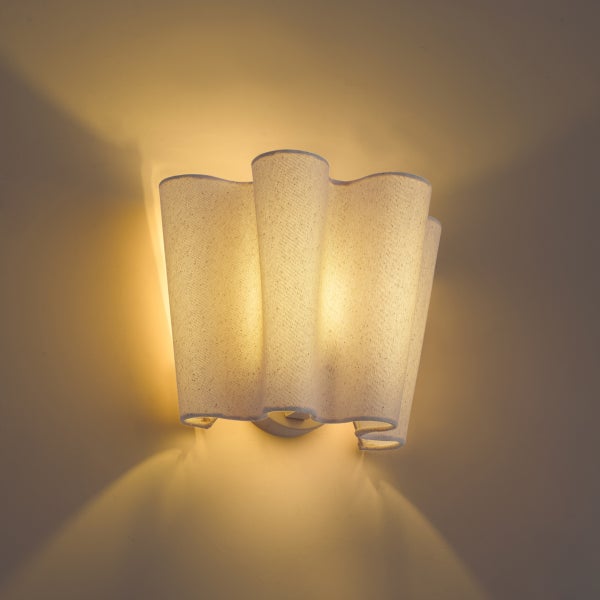 Moderne Wandleuchte aus Stoff mit wellenförmigem Design für eine stimmungsvolle Akzentbeleuchtung.