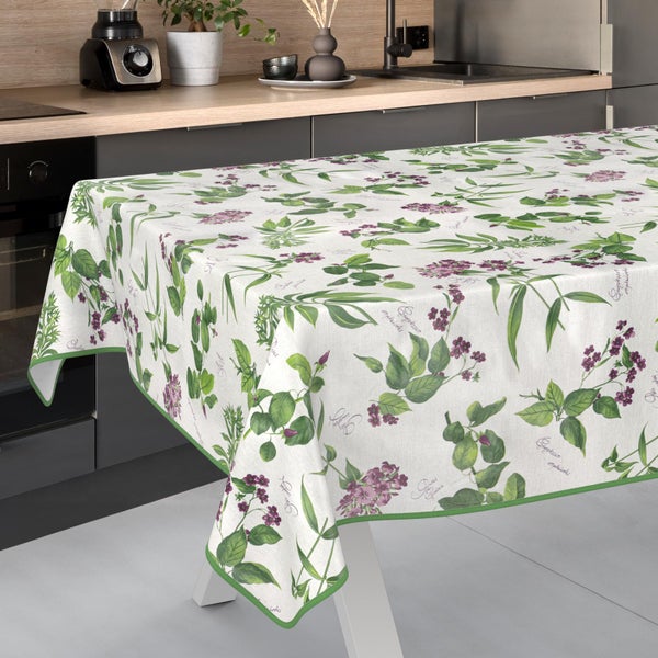 Tischdecke mit floralem Muster aus Blüten und Blättern auf einem Esstisch in einer modernen, hellen Küche.