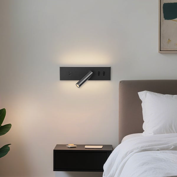 Wandleuchte mit USB-Anschlüssen über einem Nachttisch im Schlafzimmer.
