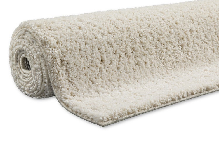 Hochflor-Teppich Shaggy aufgerollt in Beige mit weicher Struktur.
