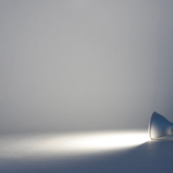 GU10 LED Reflektorlampe mit fokussiertem Lichtstrahl auf einer Fläche.