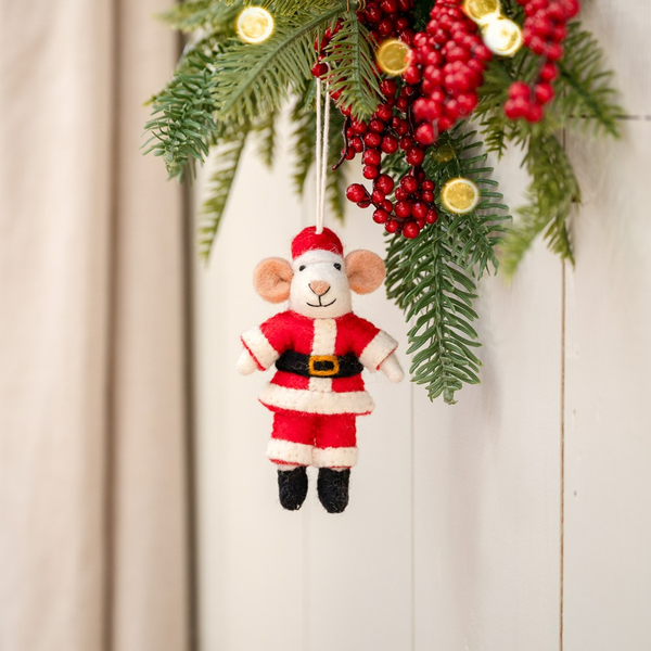 Dekorativer Weihnachtsschmuck: Maus im Weihnachtsmannkostüm an Tannenzweig mit roten Beeren