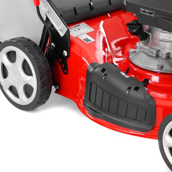 Nahaufnahme eines roten Benzin-Rasenmähers mit schwarzem Seitenauswurf, Rädern und Motorteilen.