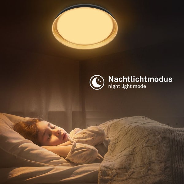 Runde Deckenleuchte im Nachtlichtmodus über einem schlafenden Kind im Bett.
