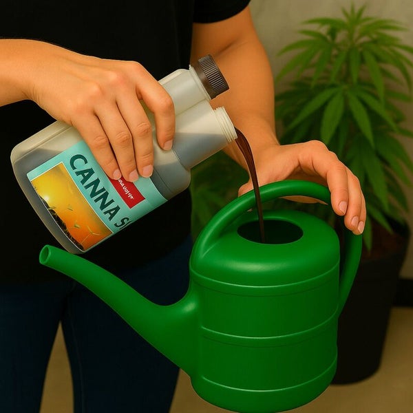 Eine Person gießt Canna Terra Vega Pflanzendünger aus einer Flasche in eine grüne Gießkanne für die Pflanzenpflege.