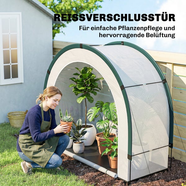 Eine Frau kniet im Garten und pflegt Topfpflanzen vor einem kleinen Foliengewächshaus mit geöffneter Reißverschlusstür für Belüftung.