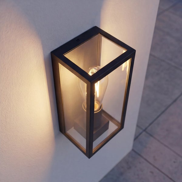 Rechteckige Außenwandleuchte aus schwarzem Metall und Glas mit leuchtendem LED-Leuchtmittel im Vintage-Stil an einer Hauswand.