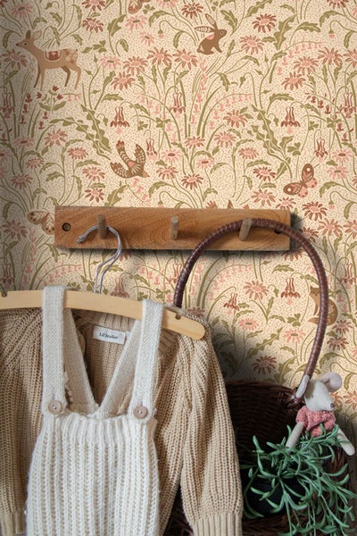 Kindertapete mit Blumen- und Tiermuster aus Rehen und Hasen, abgebildet mit einer Holzgarderobe und hängender Kinderkleidung.