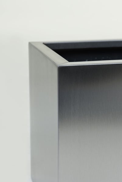 Nahaufnahme der Ecke eines rechteckigen Pflanzkübels aus gebürstetem Edelstahl.